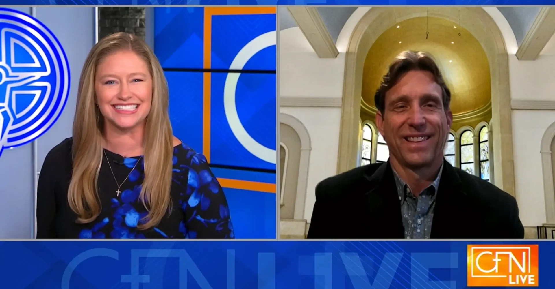 Two people smiling during a video call on a news set.
